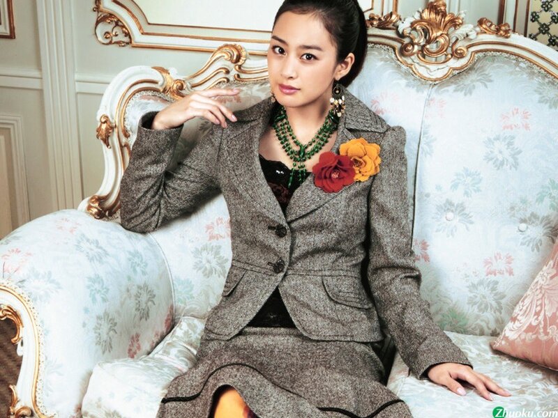 woman in suit on ornate sofa