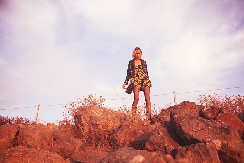 Woman in sunflower dress on rocks