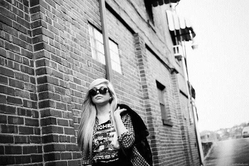 woman in sunglasses by brick wall