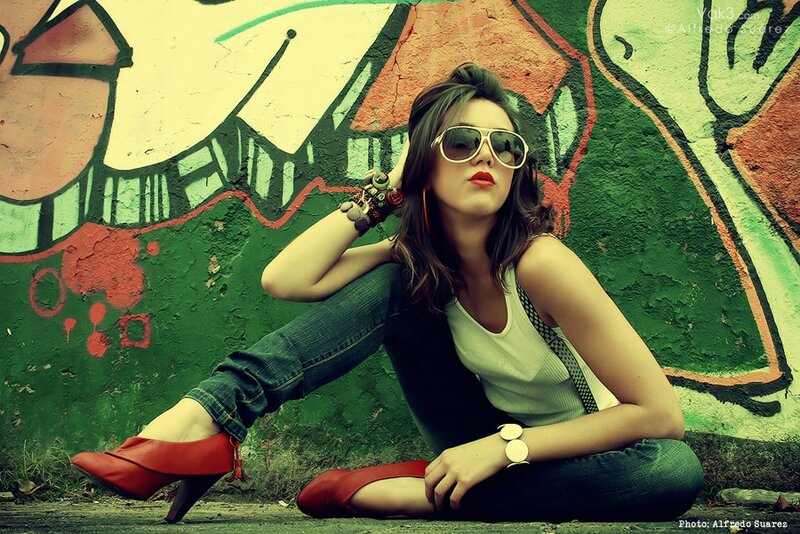 woman in sunglasses by graffiti wall