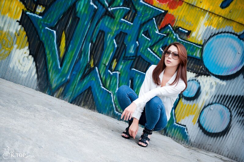 Woman in sunglasses by graffiti wall