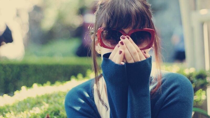 woman in sunglasses covering face