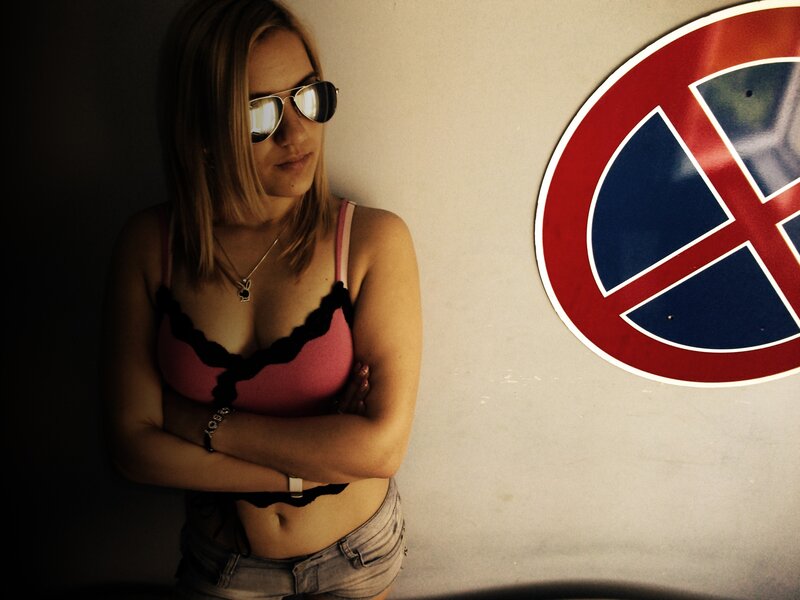 woman in sunglasses leaning against wall