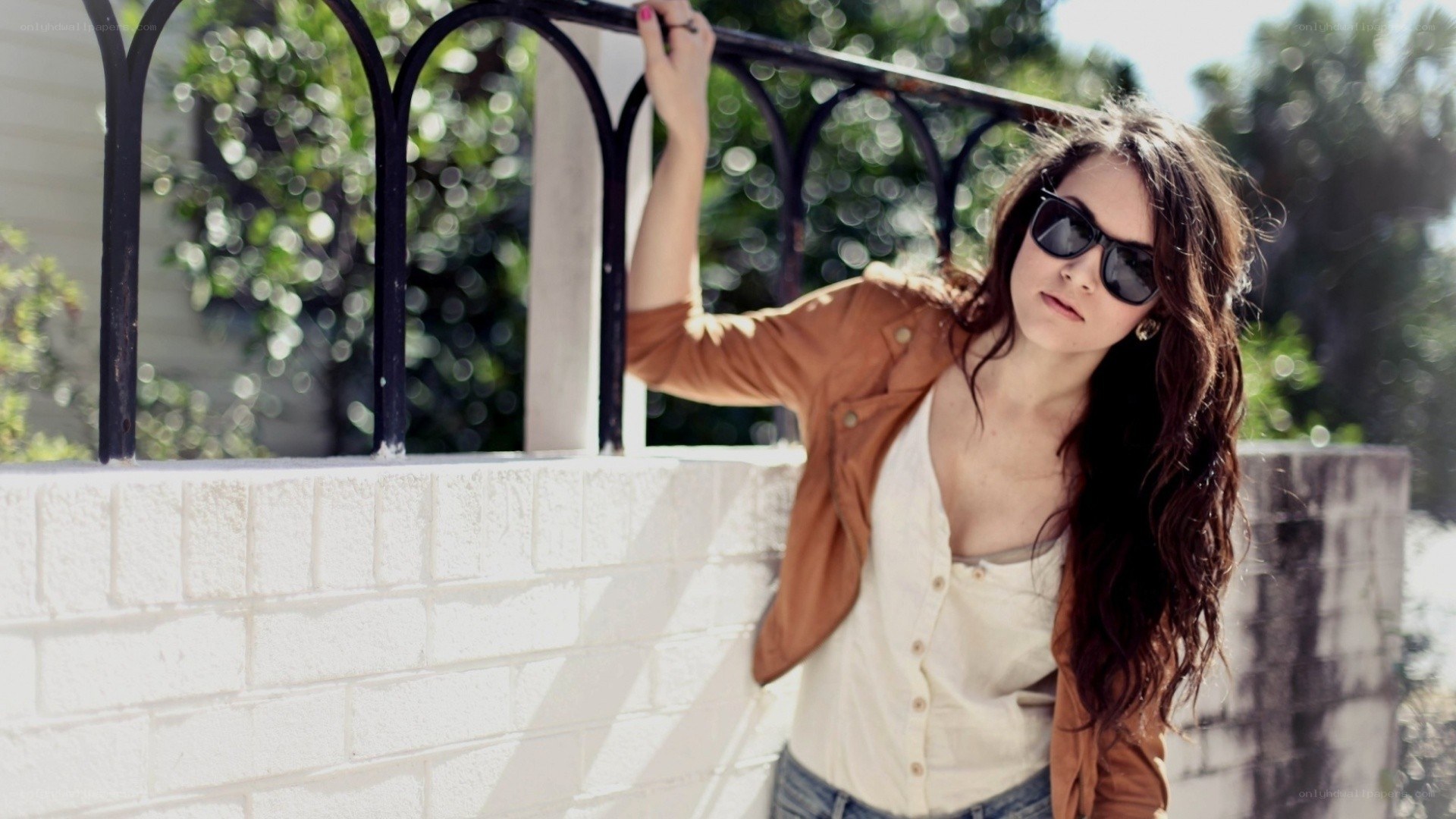 woman in sunglasses leaning on fence