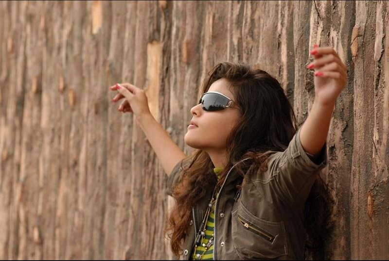 woman in sunglasses leaning on wall