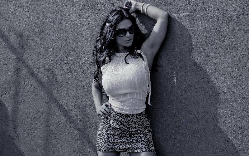 woman in sunglasses leaning on wall