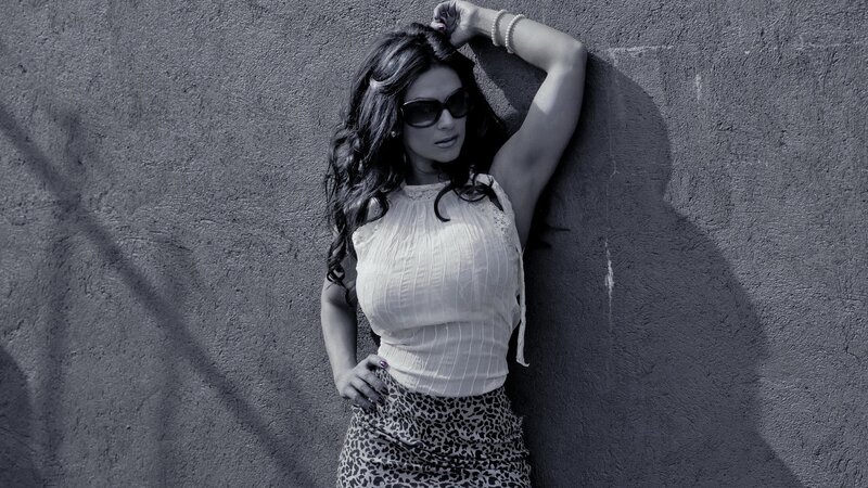 woman in sunglasses leaning on wall