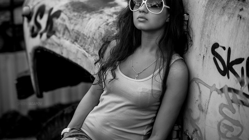 woman in sunglasses leaning on wall