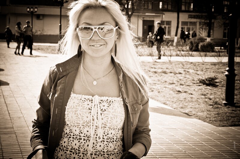 Woman in sunglasses on sidewalk