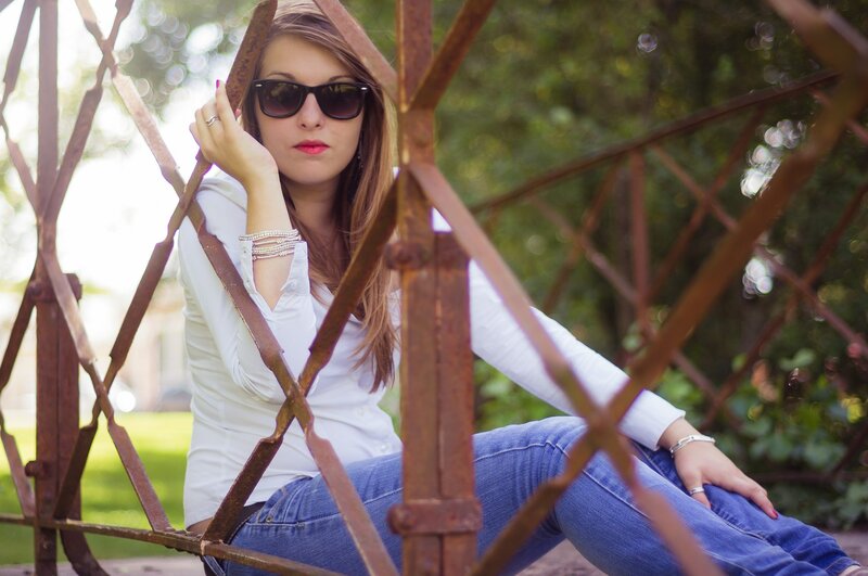 woman in sunglasses sitting on bench