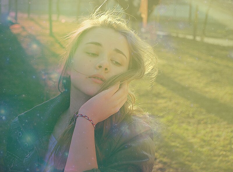 woman in sunlight with hand on face