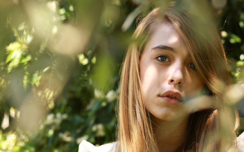 woman in sunlit foliage