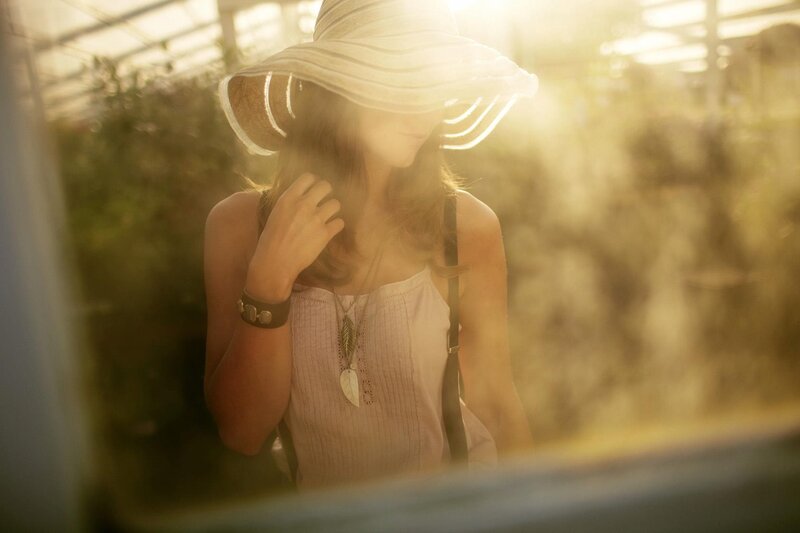 woman in sunlit greenhouse