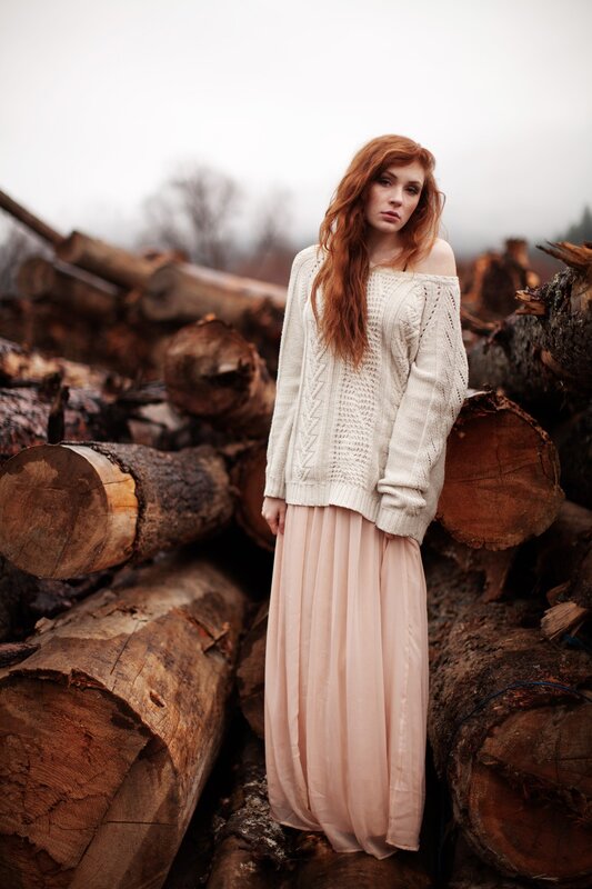 Woman in sweater among logs