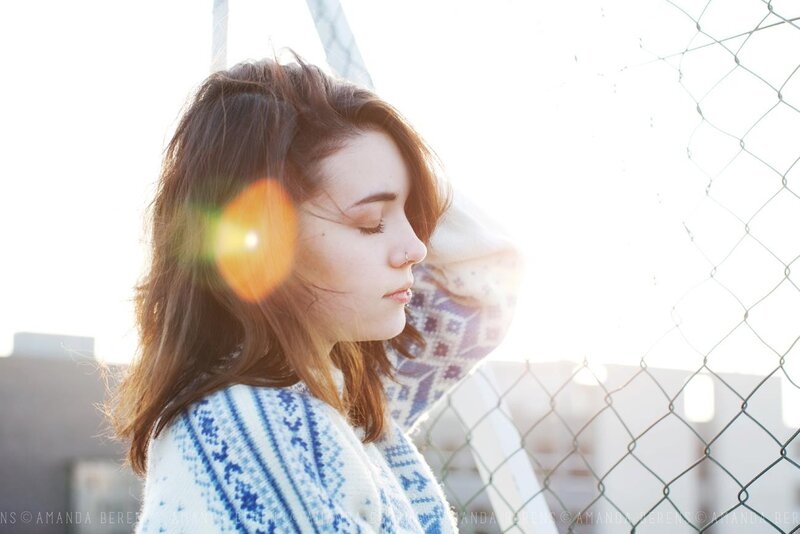 woman in sweater by fence