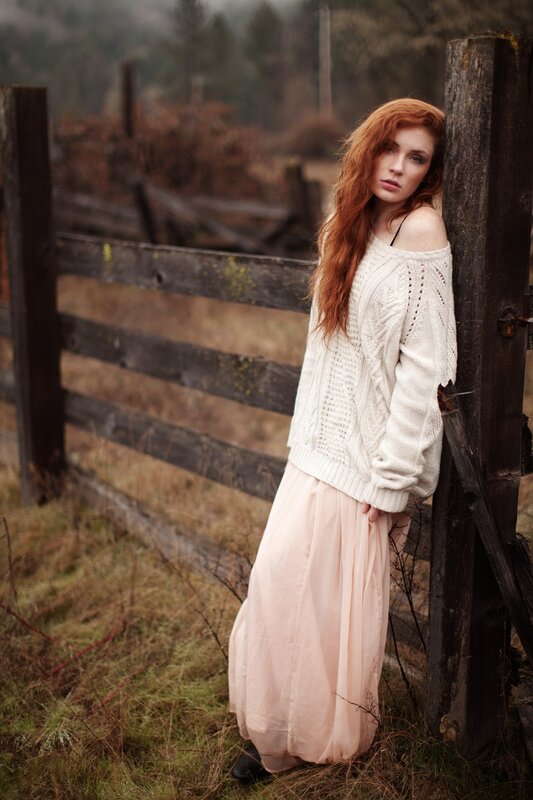 woman in sweater by fence