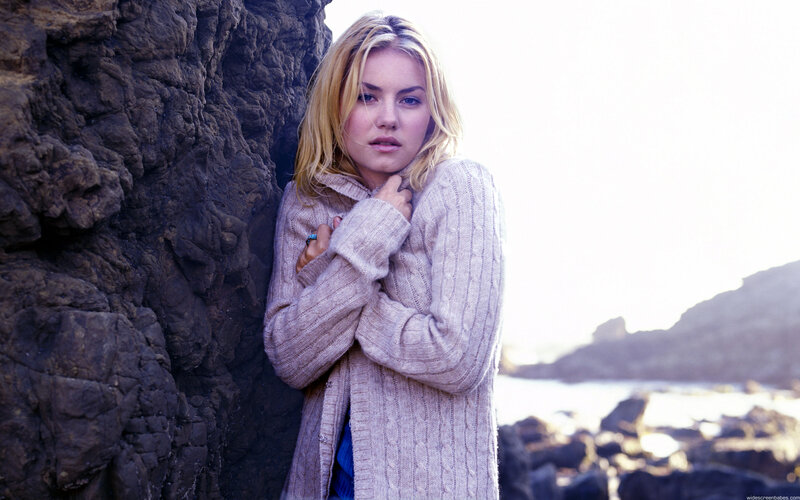 woman in sweater by rocks