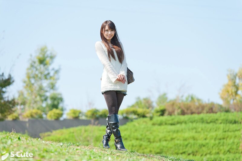 Woman in sweater on a grassy hill