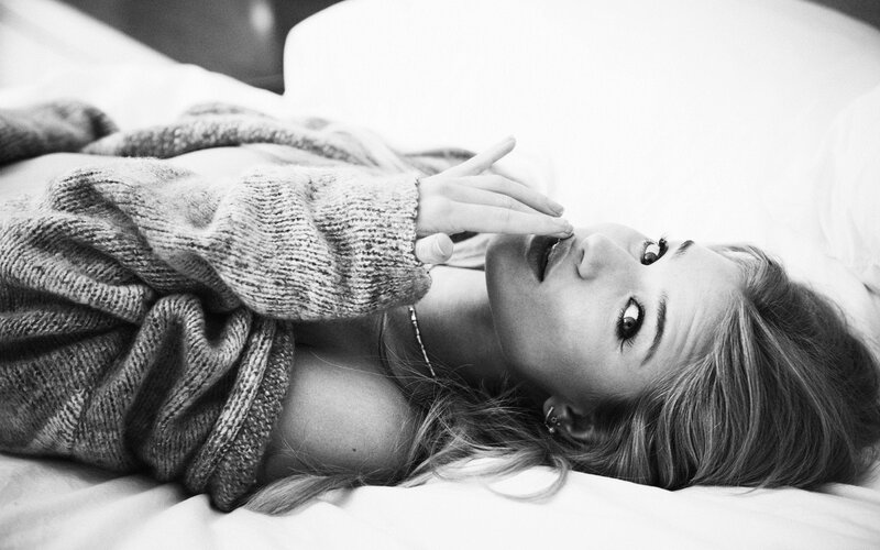 woman in sweater on bed