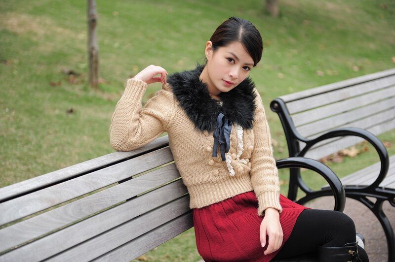Woman in sweater on park bench