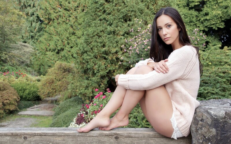 Woman in sweater sitting outdoors