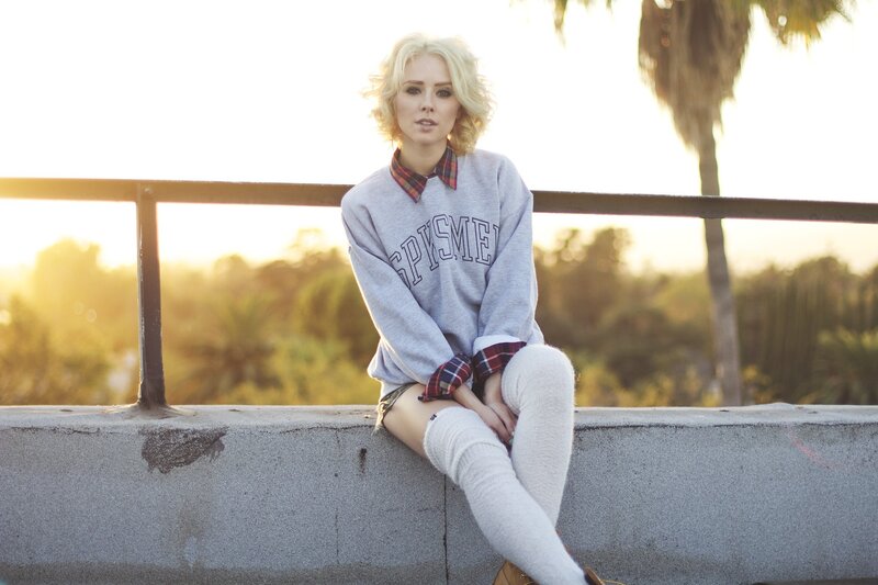 woman in sweatshirt sitting outdoors