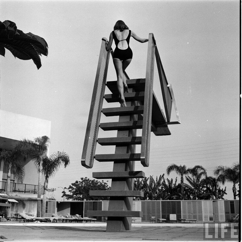 Woman in swimsuit on pool ladder