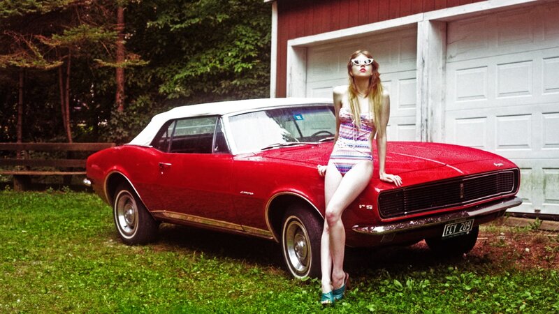 Woman in swimsuit with red car