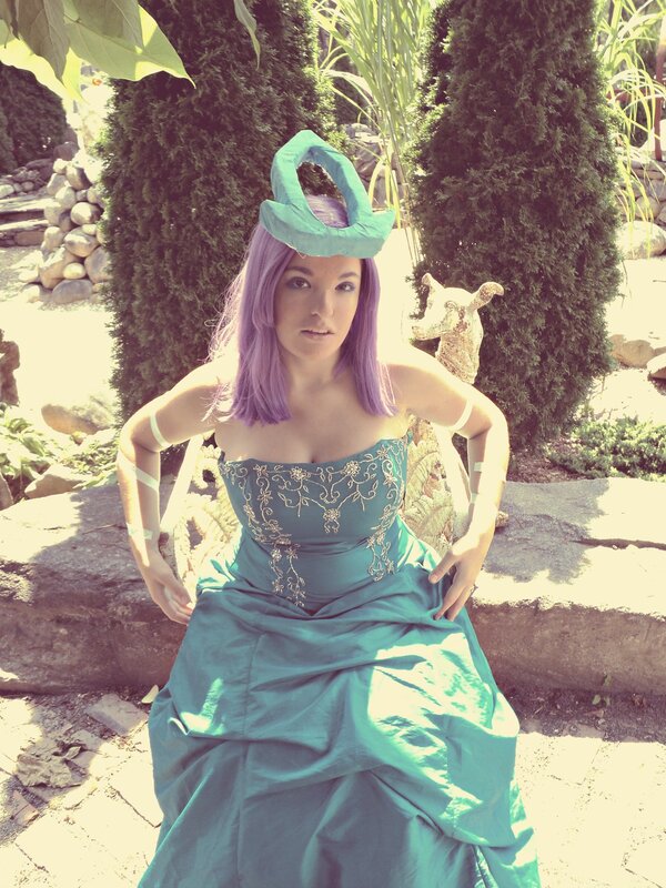 Woman in teal gown and purple wig