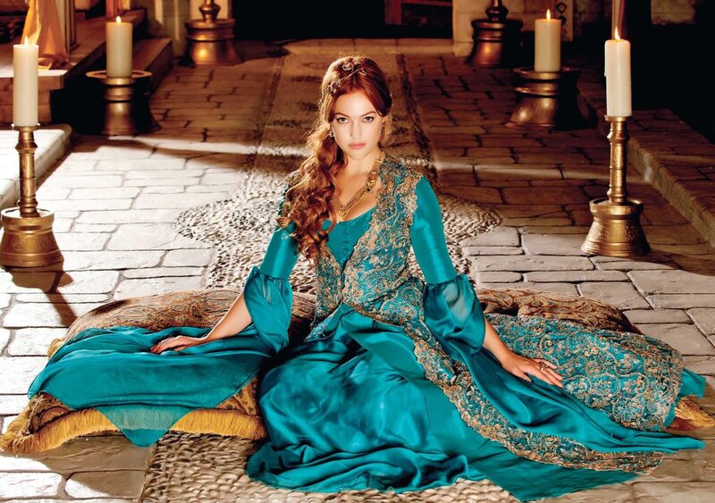 woman in teal gown sitting