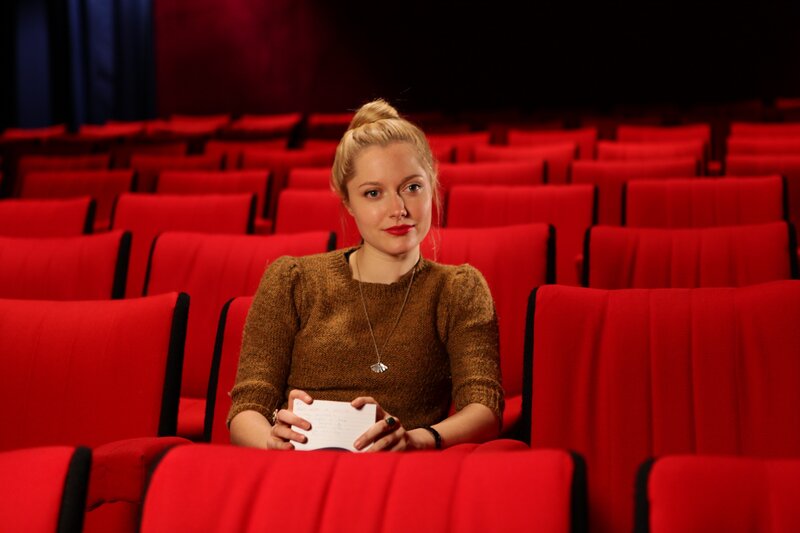 Woman in theater with notebook