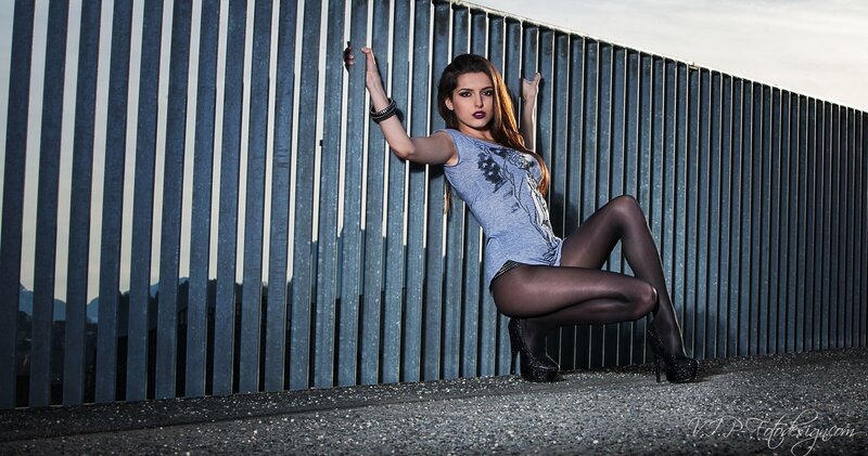 woman in tights posing by fence