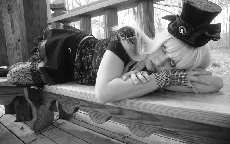 woman in top hat on bench