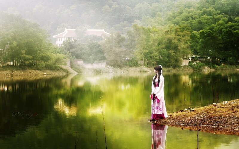 woman in traditional dress by lake