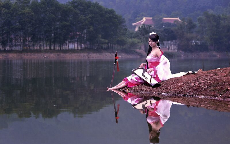 Woman in traditional dress by lake