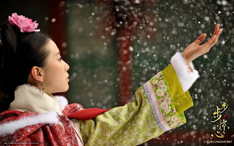 woman in traditional dress catching snow