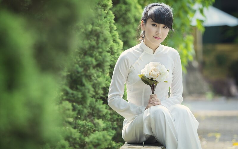 woman in traditional dress holding flowers