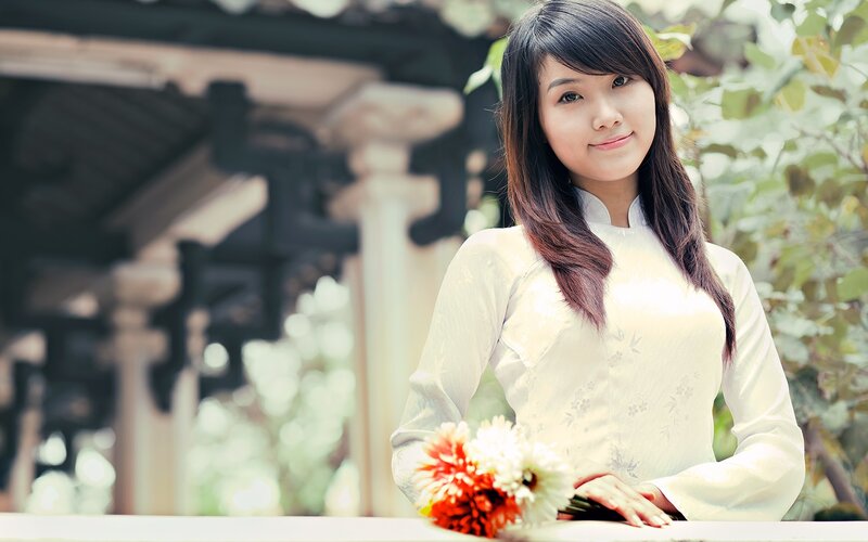woman in traditional dress holding flowers