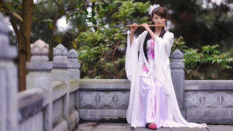 woman in traditional dress playing flute