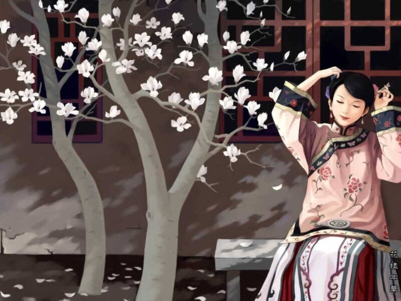 woman in traditional dress under blossoming tree