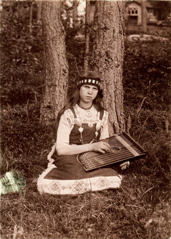 Woman in traditional dress with instrument