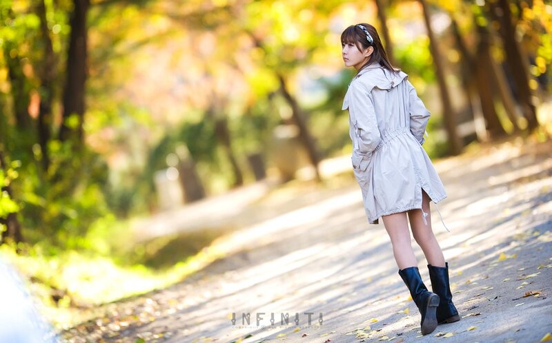 woman in trench coat on path