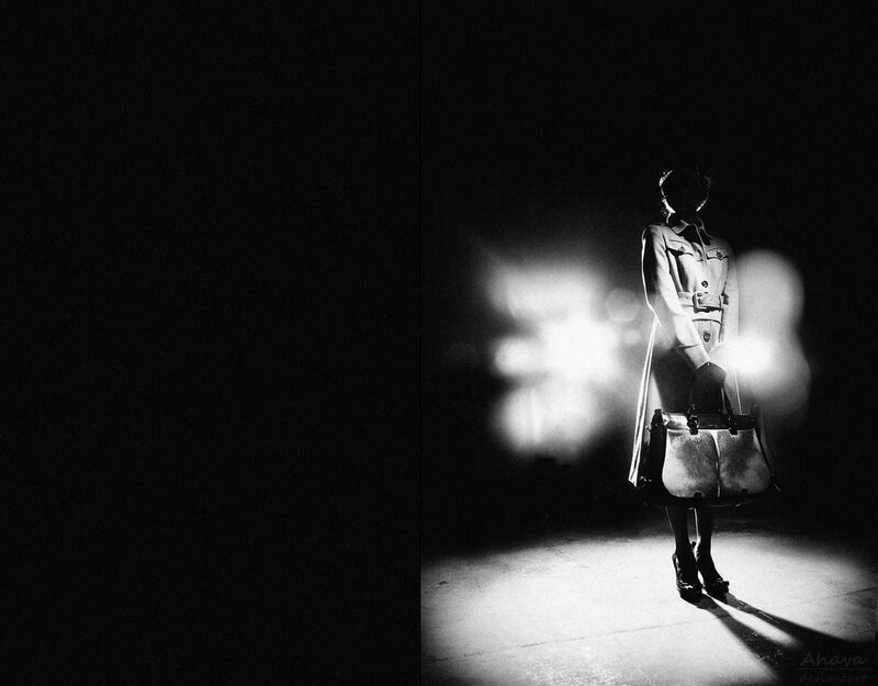 woman in trench coat under spotlight