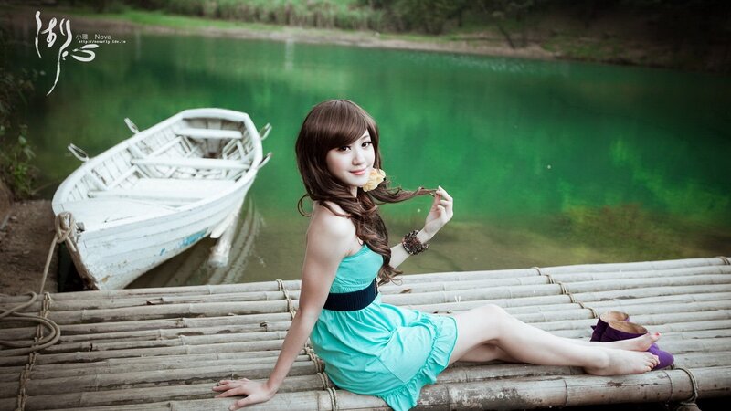 Woman in turquoise dress by lake
