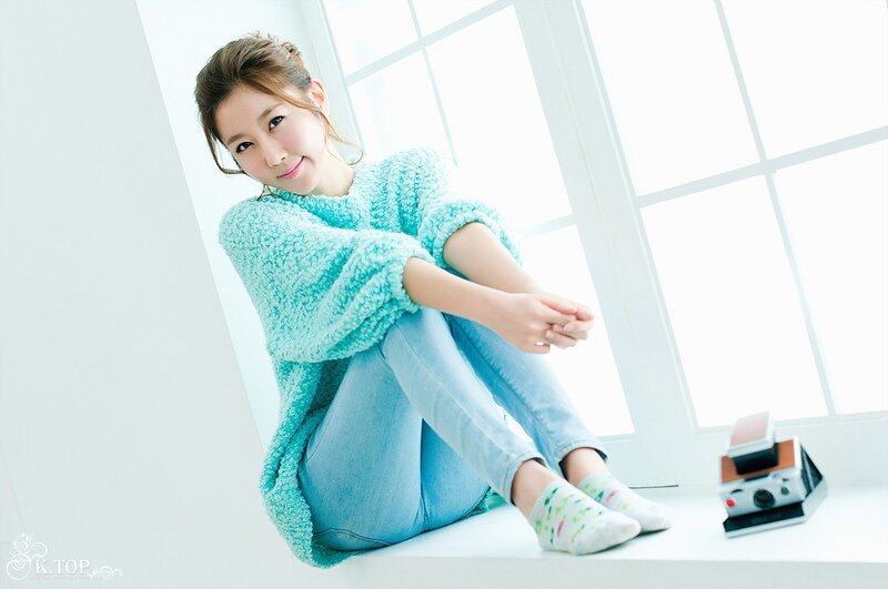 woman in turquoise sweater sitting by window