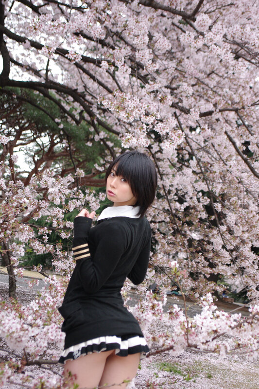 Woman in uniform under cherry blossoms