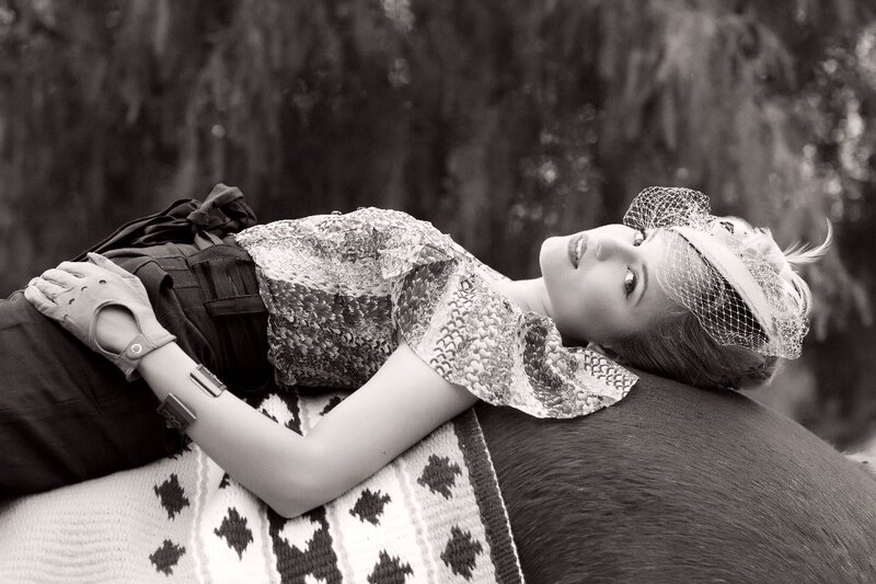 woman in vintage attire lying on horse