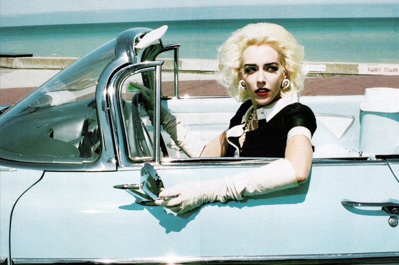 Woman in vintage car by the sea