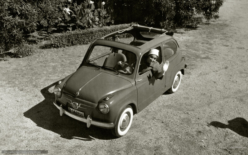 Woman in vintage car waving