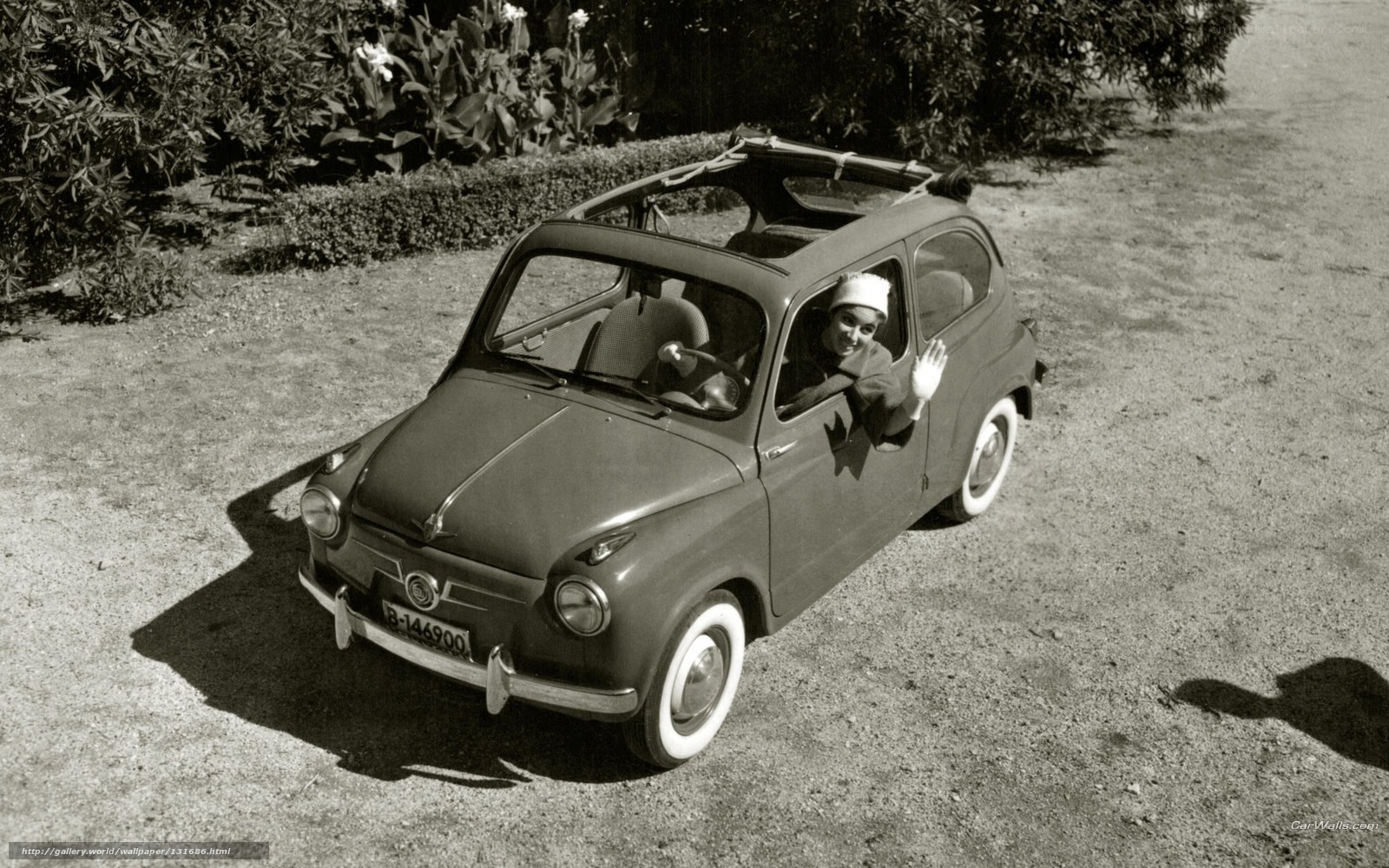 Woman in vintage car waving